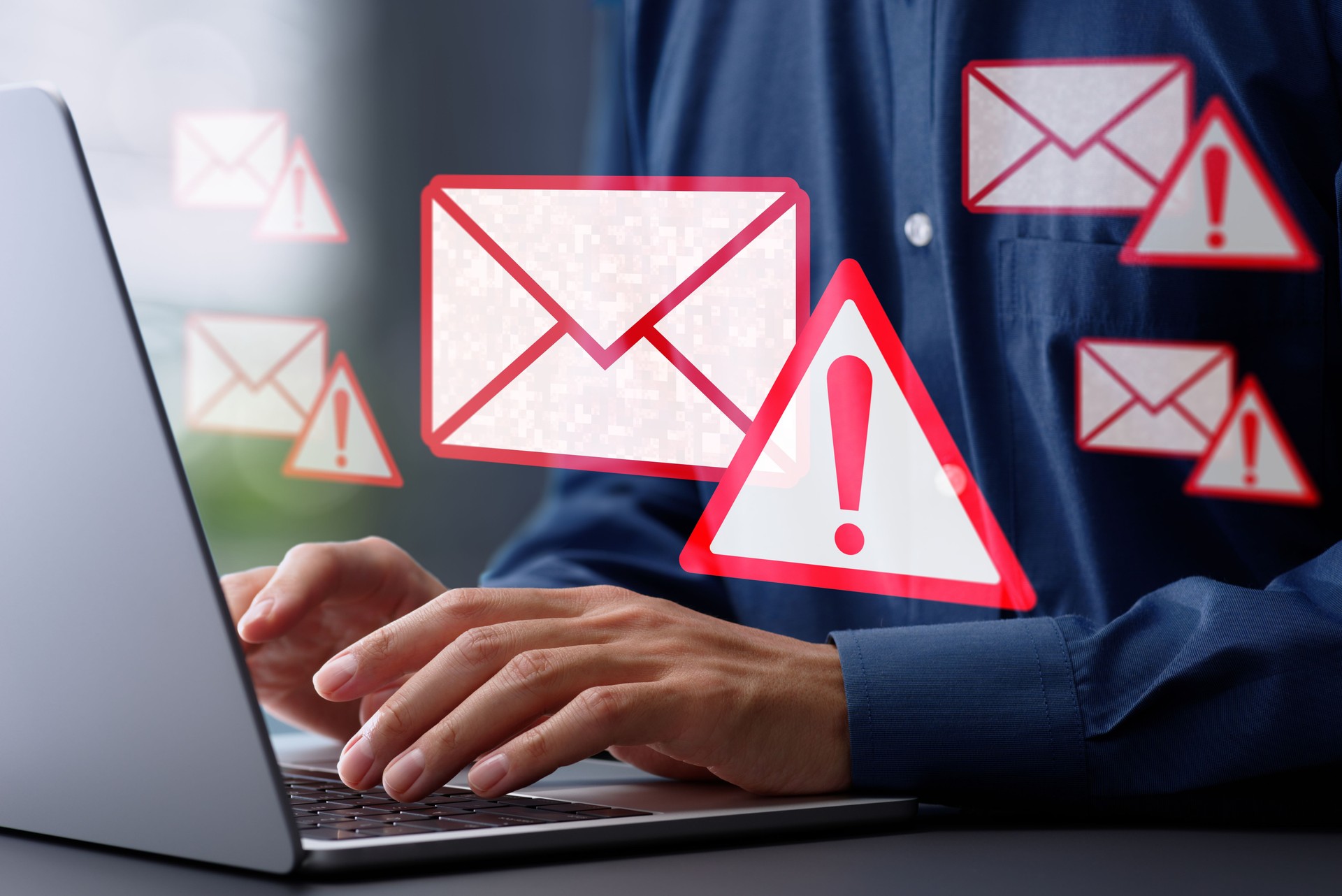 Spoofed emails and phishing scams with malicious attachments. Email and warning icons with exclamation marks. Man using laptop computer to check and respond to emails.